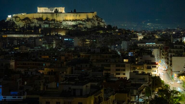 Athens airport transfer to Hilton Athens — Acropolis illuminated at night above the city